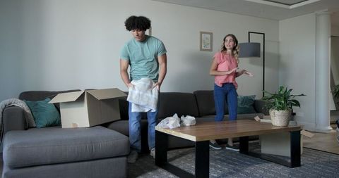 Couple unpacking in new home living room setting