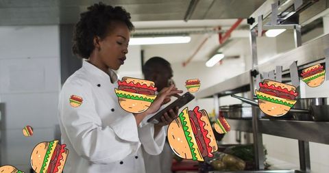 Chefs in Industrial Kitchen Managing Orders with Hamburger Graphics
