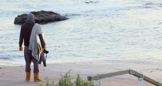 Surfer Waiting by the Sea on a Cool Morning - Download Free Stock Images Pikwizard.com