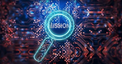 Magnifying glass highlighting mission on circuit board