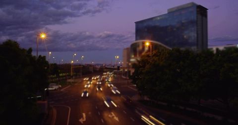 Dusk Traffic Flow Creating Light Trails on Multilane Urban Road with Glass High-Rise