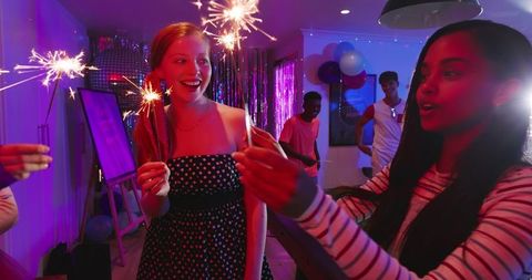 Young Friends Celebrating with Sparklers, Red-Haired in Polka-Dot Dress at Colorful Party