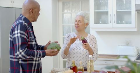 Senior Couple Enjoys Unpacking Groceries in Modern Kitchen