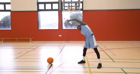Basketball Player Warming Up in Gym Before Practice