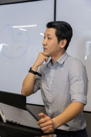 Professional Man Leading Business Presentation With Pie Chart