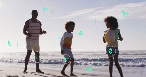 Joyful family beach day with father and children playing beach ball