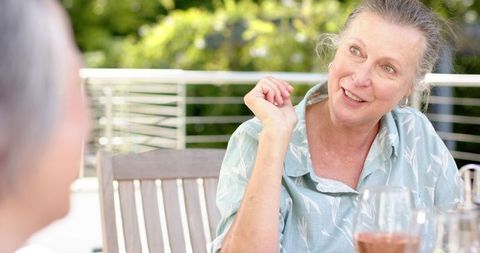 Senior Friends Sharing Conversation Outdoors on Sunny Day