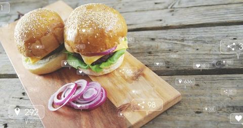 Serving rustic sesame cheeseburgers on wooden board with onion rings and social icons