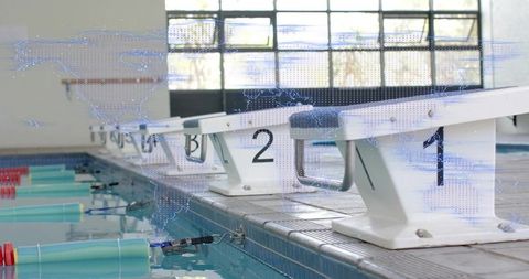 Starting blocks on pool deck, reflecting turquoise lane floats and daylight through windows