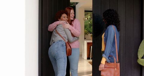 Diverse Female Friends Hugging at Home Entrance