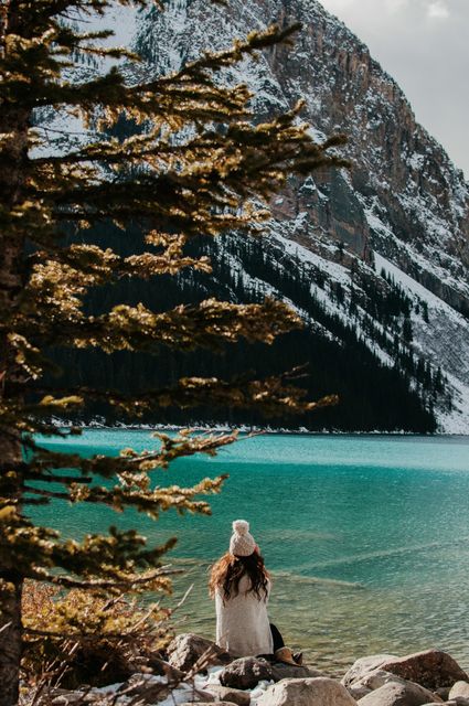 Woman Sitting by Lake with Snow-Covered Mountain Background - Download Free Stock Images Pikwizard.com