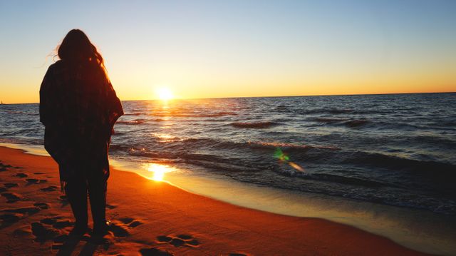 Woman Watching Sunset on Tranquil Beach - Download Free Stock Photos Pikwizard.com