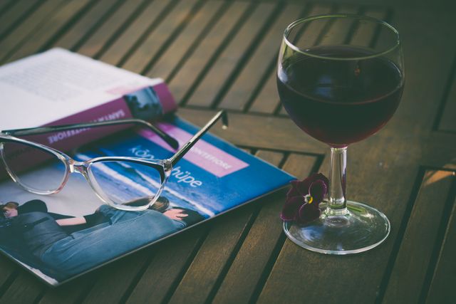 Glasses and Magazine on Wooden Table with Glass of Red Wine - Download Free Stock Photos Pikwizard.com
