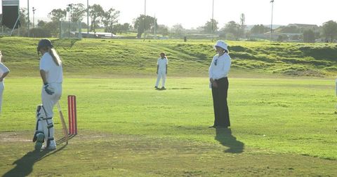 Female Cricketer Waiting to Bat Under Bright Sunlight on Green Field - Download Free Stock Images Pikwizard.com