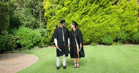 Graduates in Caps and Gowns Celebrating Achievement in Garden