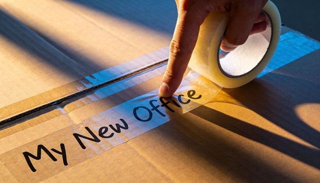 Sealing packing tape on box labeled my new office for home office move and relocation