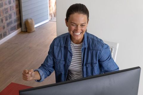Woman Celebrating Victory While Working from Home