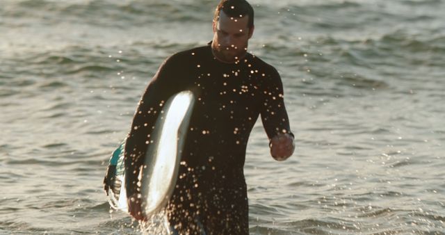Man Emerging from Ocean with Surfboard at Sunset - Download Free Stock Images Pikwizard.com