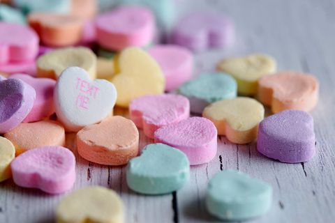 Colorful heart-shaped candy close-up on rustic wooden surface