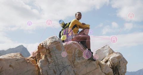 Hiker Resting on Rocky Summit Engaging in Adventure Travel