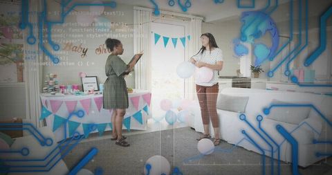 Two women planning modern baby shower with pastel decor and balloons in bright living room