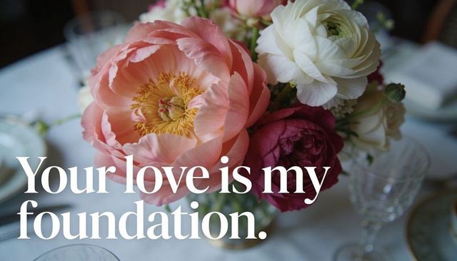 Romantic peach peony and ranunculus bouquet featuring love quote on dining table