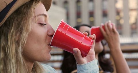 Close-Up of Friends Enjoying Drinks at Rooftop Party