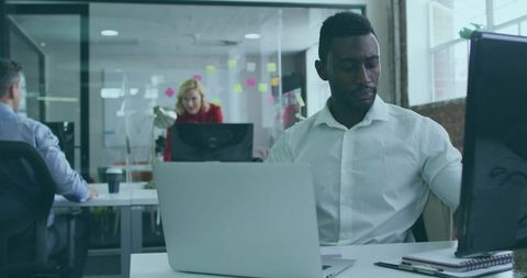 Business Professional Adjusting Monitor in Modern Open-Plan Office