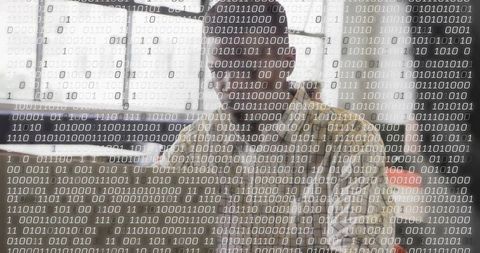 Software developer coding at desk with transparent binary code overlay