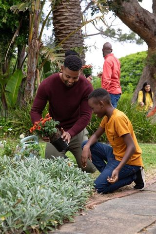 African american father and son bonding in vibrant backyard