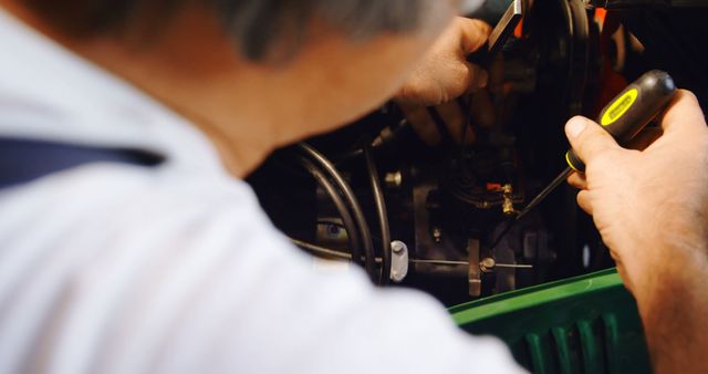 Mechanic Repairing Engine with Screwdriver in Workshop - Download Free Stock Images Pikwizard.com