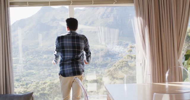 Man Enjoying Scenic Mountain View Through Large Windows - Download Free Stock Images Pikwizard.com