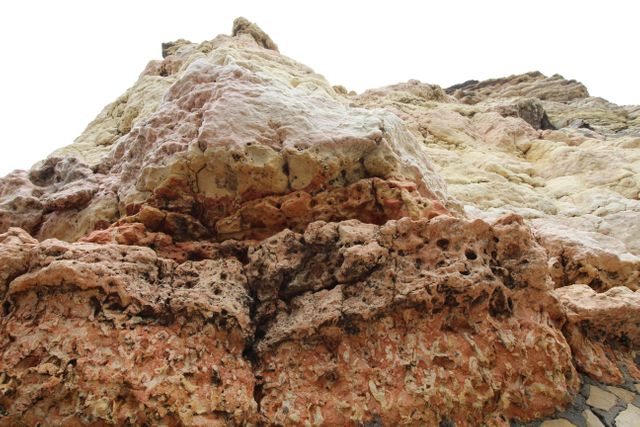 This visual captures a close-up view of a stunning rock formation showcasing intricate textures, colors, and geological layers. It is perfect for use in educational content about geology, nature backgrounds, outdoor adventure themes, travel brochures, and geological studies. It highlights the beauty and complexity of natural rock formations, promoting interest in natural sciences and environmental awareness.