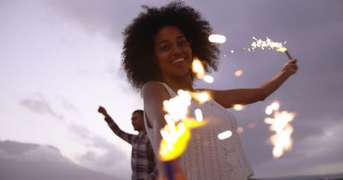 Young Couple Enjoying Sparklers on Beach at Dusk - Download Free Stock Images Pikwizard.com