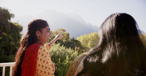 Smiling Women in Traditional Attire Enjoying Outdoor Scenic View