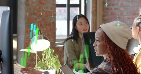 Diverse Women Collaborating at Modern Loft Workspace Using Computers and Creative Planning