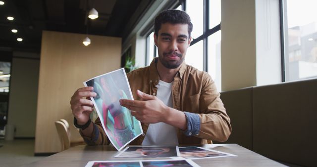 Young Creative Man Reviewing Colorful Designs in Modern Office - Download Free Stock Images Pikwizard.com