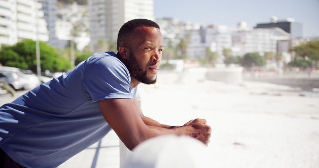 Man relaxing by the seaside with cityscape in background - Download Free Stock Images Pikwizard.com