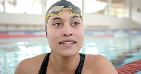 Female swimmer in pool smiling after training session