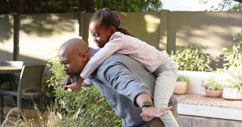 Father and Daughter Enjoy Fun Piggyback Ride Outdoors
