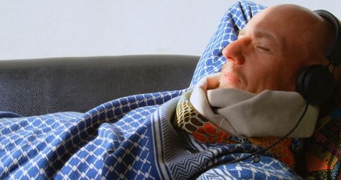 Relaxed man enjoying music on sofa at home