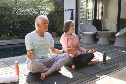 Senior Couple Meditating by Pool for Relaxation and Wellness
