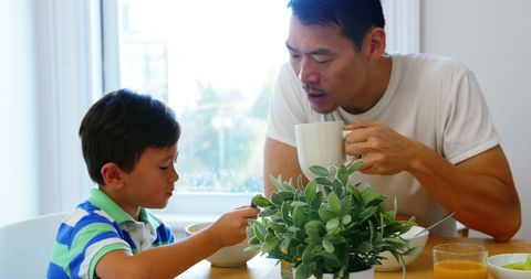 Father and Son Eating Breakfast in Cozy Home Kitchen