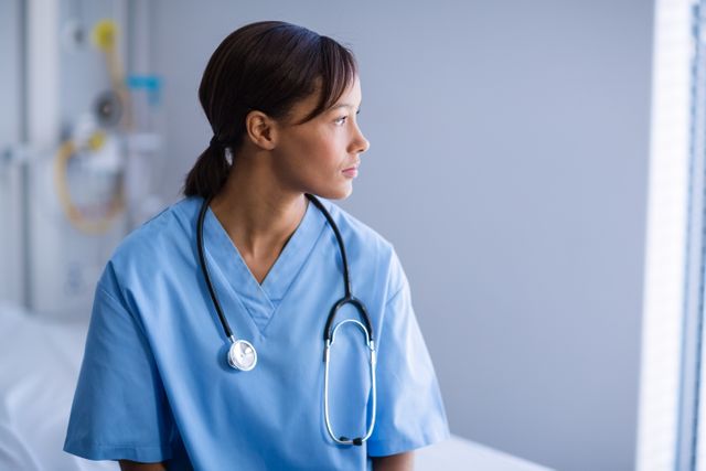 Thoughtful female doctor sitting in ward of hospital