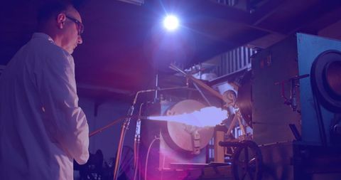 Skilled Craftsman Using Flamethrower in Dimly Lit Workshop