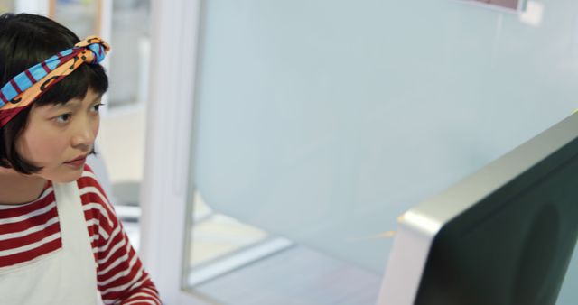 Focused Young Woman Working On Computer with Headband in Office - Download Free Stock Images Pikwizard.com