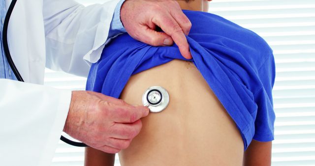 A Caucasian doctor is examining a young boy's back using a stethoscope, with copy space - Download Free Stock Photos Pikwizard.com