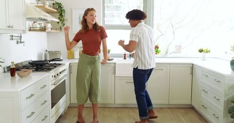 Couple Enjoying Dance Routine in Bright Modern Kitchen