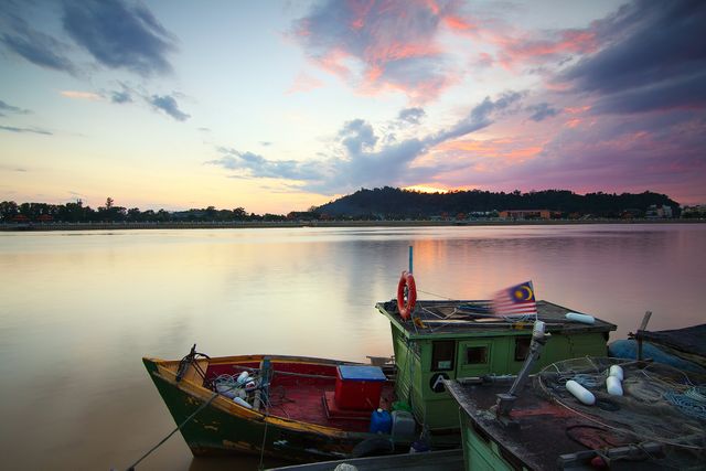 Traditional Fishing Boat at Vibrant Sunset Reflecting on Calm River - Download Free Stock Photos Pikwizard.com