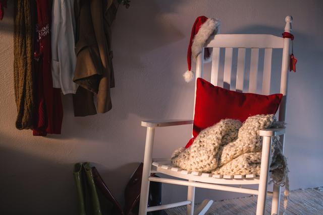 Wooden chair with red pillow and santa hat at home